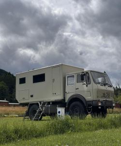 拉德库夫Góry Stołowe Camp -miejsce na kamper, przyczepę lub namiot的一辆白色的卡车停在田野里