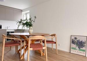 苏黎世Urban Oasis - 2BR Apartment near Bahnhof Zürich Oerlikon -302-的餐桌和椅子,上面有花瓶