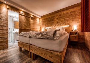 阿罗萨阿罗萨维特酒店的一间卧室设有一张床和木墙