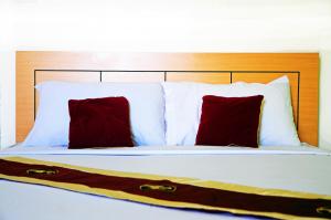 清迈丘克它维微笑酒店的一张带两个红色枕头的床