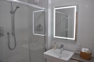 因弗鲁里Westgate Apartments Birchlee的浴室配有盥洗盆和带镜子的淋浴