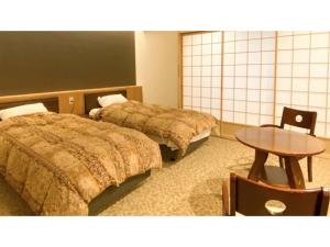 坂井市Takekurabe - Vacation STAY 60412v的酒店客房设有两张床和一张桌子。