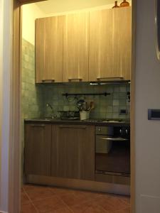 RovereAppartamento Arnolucci的厨房配有木制橱柜和炉灶烤箱。
