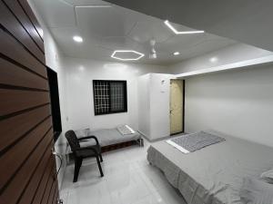 AkalkotVatavriksha Guest House,Akkalkot的一间卧室配有一张床和一把椅子