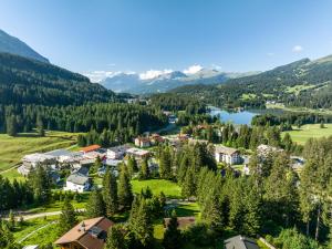 伦策海德Valbella Resort的享有湖泊和山脉的度假村的空中景致