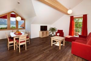 里登施诺利尔湖滨公寓的客厅配有红色的沙发和桌子