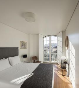 里斯本里斯本服务式公寓 - 拜萨堡的一间卧室设有一张大床和一个大窗户