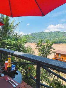 琅勃拉邦Luang Prabang Mekong Charm River View的露台配有遮阳伞,享有海滩美景。