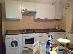 滨海库普拉Appartamento Via Adriatica Nord的厨房配有白色橱柜和洗衣机。
