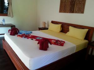 象岛幸运壁虎花园旅馆的一间卧室配有一张红色装饰的大床