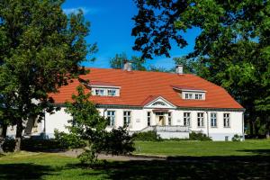 KihelkonnaLoona Manor Guesthouse的一座白色的大房子,有橙色的屋顶