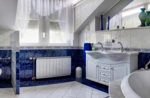 布达佩斯疗养别墅的蓝色和白色的浴室设有水槽和浴缸。