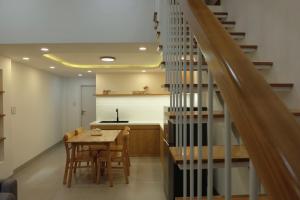 岘港Central, Minimalist and Cozy - Gau's House的一间带桌子和楼梯的用餐室