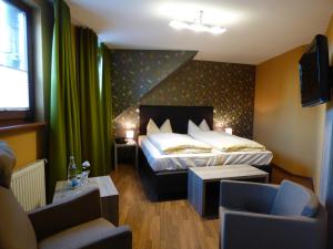WeyherZum Kronprinzen Hotel Garni的酒店客房配有一张床、一张沙发和椅子。