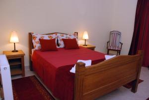 贝尔格莱德Kuca Veljovica的一间卧室配有一张带红色床单的床和两盏灯。