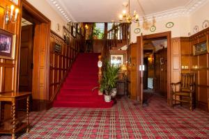 斯佩河畔格兰敦缇娜斯格特斯乡村房屋酒店的走廊上铺有红地毯,设有楼梯