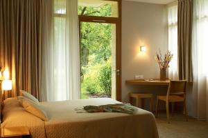 罗卡马杜尔艾斯克拉尔奇酒店的一间卧室配有一张床、一张书桌和一个窗户。