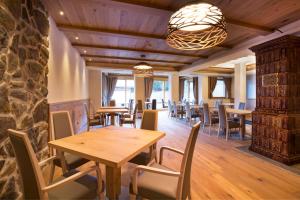 坎皮泰洛迪法萨马尔科拉酒店的一间设有木桌和椅子的餐厅以及石墙