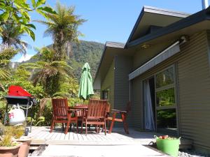 弗朗兹约瑟夫法兰士·约瑟夫树顶度假屋的庭院配有桌椅和遮阳伞。