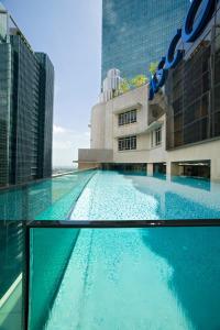 新加坡Ascott Raffles Place Singapore的大楼前的大型游泳池