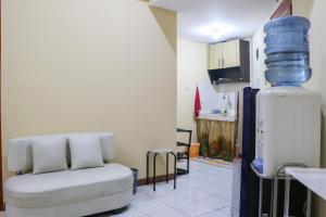 万隆Best Deal 2BR at Buah Batu Park Apartment By Travelio的带沙发和冰箱的客厅