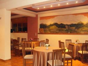 科尼察阿乌斯酒店的一间设有桌椅的房间和墙上的绘画
