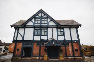 埃德温斯托The Dukeries Lodge, Edwinstowe, Nottinghamshire的一座黑白的旧建筑,有商店