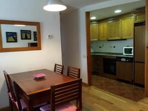 贝纳斯克Apartamento Lamatriz Dequin Edificio Sayo 8的厨房以及带木桌的用餐室。