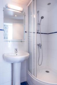巴黎Hotel des Arts - Cite Bergere的白色的浴室设有水槽和淋浴。