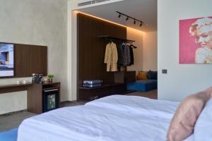 索非亚Adella Boutique Hotel - Free Secured Parking的一间卧室配有一张床和电视,另一间卧室配有梳妆台