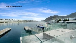 富查伊拉Al Dana Paradise Luxury Villas Palm Fujairah Sea View的船停靠在水面上的码头