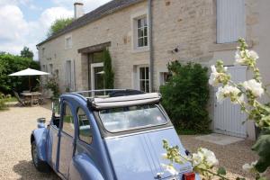 莫索特Gîte La Maison De Lucien的停在房子前面的蓝色小汽车