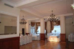Bieruń Nowy阿德里亚旅馆的大房间设有白色椅子和吊灯