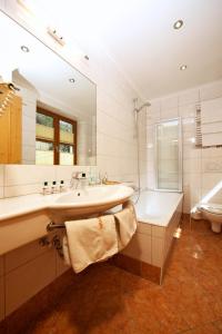 瓦格赖恩格拉芬维特酒店的一间带水槽、浴缸和卫生间的浴室