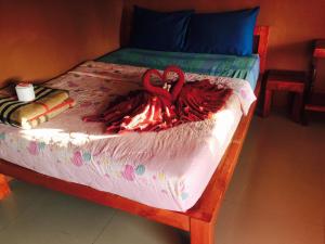 沙美岛密斯蒂姆楼酒店的一张床上有两个红色天鹅的睡床