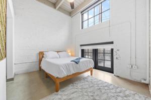 克利夫兰108- The Cozy Comfy Spacious Loft Wi-Fi Parking Cafe的白色的卧室设有床和大窗户