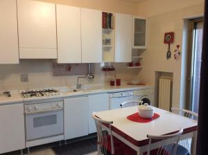 莫诺波利Casa Ariosto的厨房配有白色橱柜和碗桌
