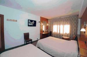 安道尔城海梅尔酒店的酒店客房设有两张床、一张书桌和一个窗户。
