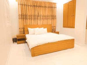 卡拉奇Stay Inn Hotel Rooms Karachi - Gulshan - Agha Khan Hospital - Airport的一间卧室配有一张木床和窗户