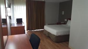 内普顿市水晶酒店 -海王星的配有一张床和一张书桌的酒店客房