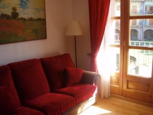 贝纳斯克Apartamento Lamatriz Dequin Edificio Sayo 8的客厅,在门边设有红色沙发