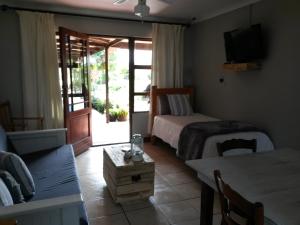Molen Drift非洲之日旅馆的一间卧室配有一张床、一张桌子和一张沙发