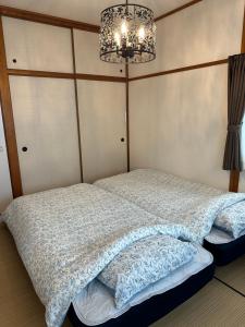 下关Guest House "Ro"kumano的一间卧室配有一张带吊灯的床