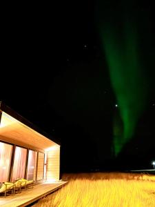 瓦德瑟Ekkerøy Lodge - Arctic living的一座带椅子的建筑,天空中充满极光