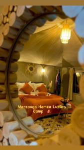 梅尔祖卡Merzouga Hamza Luxury Camp的镜子中卧室的反射,镜子中的床