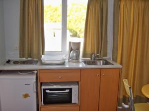 科斯镇花样年酒店公寓的厨房配有水槽、微波炉和窗户