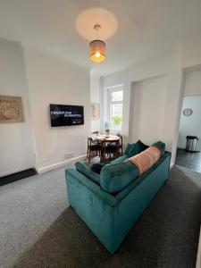 巴里Spacious Barry Island House Sleeps 8 Dog Friendly Family with Garden Space and Breakfast Included的客厅配有沙发和桌子