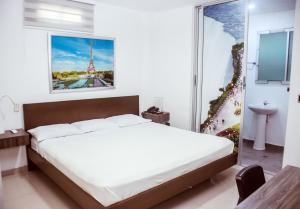 巴兰基亚Hotel Suites Caribe的一间卧室配有一张床,享有艾菲尔铁塔的景色