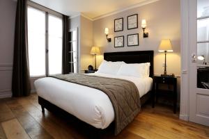 巴黎圣路易皮嘉尔酒店的一间卧室设有一张大床和两个窗户。