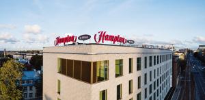 塔林Hampton By Hilton Tallinn的上面有红色 ⁇ 虹灯标志的建筑